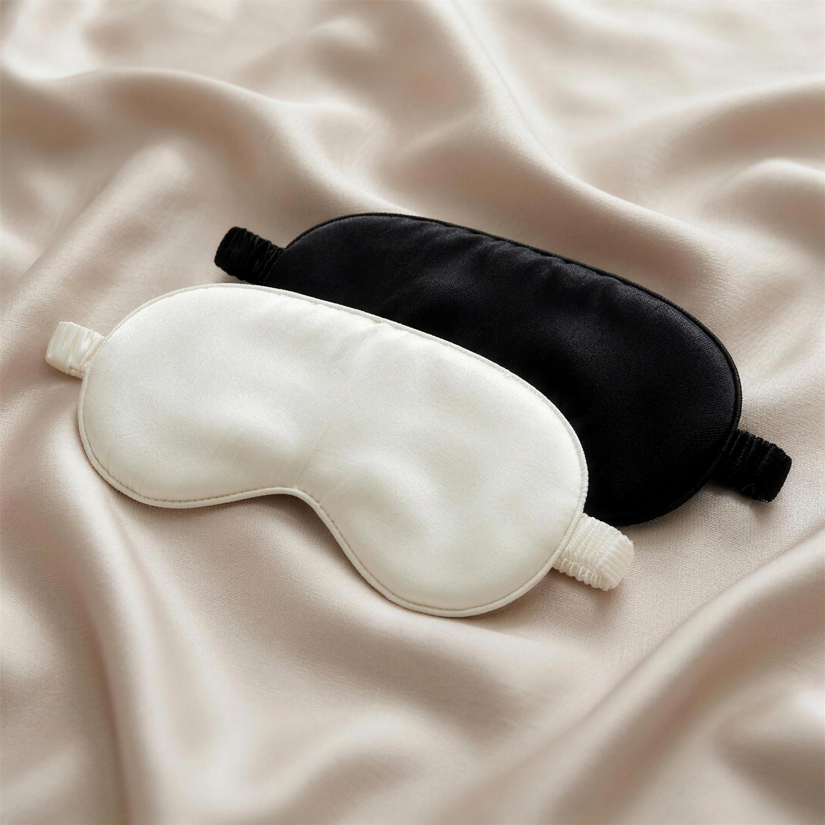 OASISÉ Mulberry Silk Eye Mask in white and black on a soft silk surface